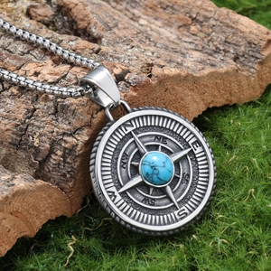 Detailed shot of Viking compass pendant with turquoise inlay on mossy wood