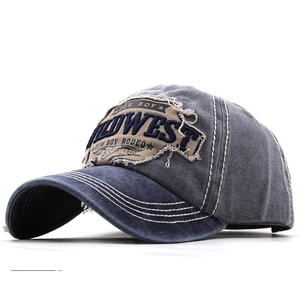 Detail of vintage patchwork baseball cap with WILDWEST embroidery and distressed stitching