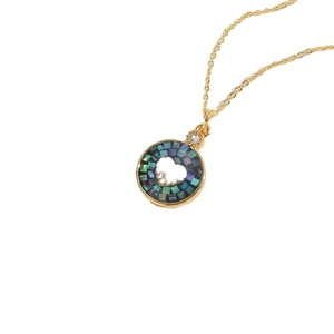 Collier avec pendentif cœur en nacre colorée, chaîne dorée et zircon sur fond blanc