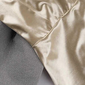 Gros plan détaillé du tissu en satin champagne doré et de la qualité des coutures