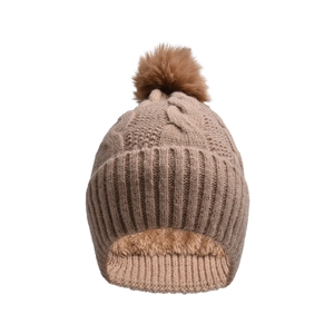 Detail of warm cable knit winter beanie with soft fleece lining and fluffy pompom