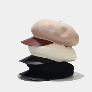 Detail of wool beret hats with leather brims in beige and black color combinations