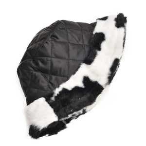 Detail of winter bucket hat with black quilted crown and plush cow print faux fur brim