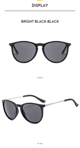 Detail view of round sunglasses with glossy black frames and slim silver metal temples