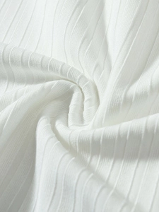 Detailed close-up of premium white ribbed knit fabric texture and soft elastic weaving