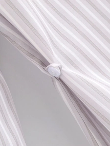 Macro detail of striped fabric texture and white button on a padded shoulder shirt