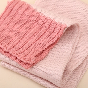 Gros plan sur un ensemble écharpe tricotée rose avec texture côtelée et détails doux