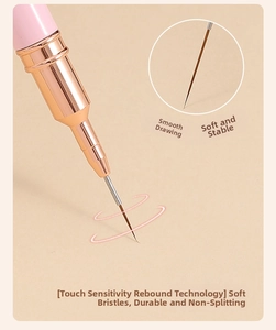 Macro detail of ultra-fine nail art liner brush with pink handle and rose gold ferrule