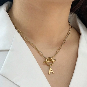 Gold paperclip chain OT buckle necklace featuring a sparkling letter A pendant