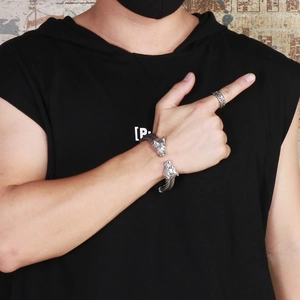 Close-up of punk style silver wolf head bracelet and matching ring on model wrist