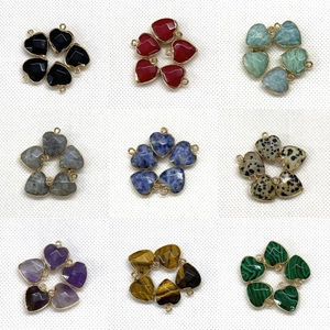 Macro shot of 9 colorful heart-shaped gemstone flower pendants with gold-plated edges