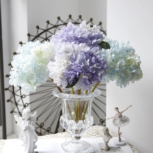 Close-up of vintage purple and blue gradient faux hydrangeas in a glass vase decoration