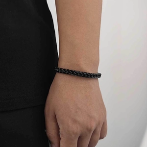 Close-up of a men's matte black stainless steel wheat link chain bracelet on a wrist