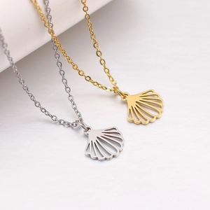 Vue macro des colliers pendentifs coquillage évidés en acier inoxydable doré et argenté