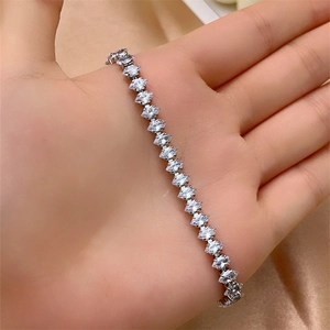 Macro detail of silver tone bracelet with sparkling marquise-cut zircon in claw setting