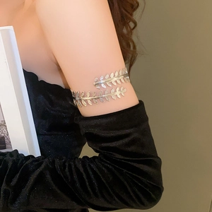 Detailed side view of a silver leaf-shaped metal upper arm cuff bracelet on a model
