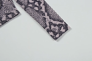 Detail of purple snake print sleeve with flatlock stitching on elastic knit fabric