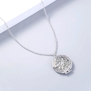 Dettaglio di una collana con medaglione rotondo argento e motivi geometrici intagliati