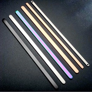 Detailed view of polished C-shaped steel cuffs in gold, rose gold, silver, black, and rainbow