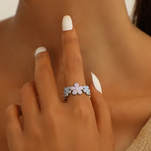Floral open ring with colorful enamel flower petals and leaves on a model finger