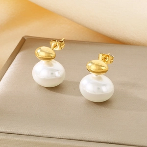 Detail of French style gold plated pearl earrings with elegant texture background