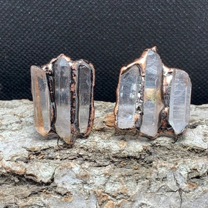 Macro shot of three natural white crystal hexagonal columns on antique bronze ring