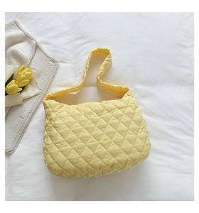 Detail of yellow quilted cloud shoulder bag with soft padding and rhombus texture