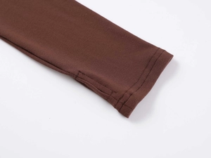 Close-up of ribbed cotton bodysuit sleeve with functional thumb hole design in brown