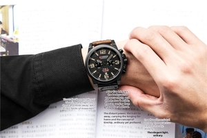Detail view of a men's quartz chronograph watch with black dial and brown leather strap
