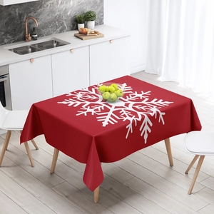 Red Christmas tablecloth with white snowflake patterns on a wooden dining table