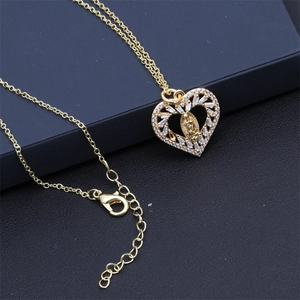 Detailed macro view of the gold heart pendant with Virgin Mary and zircon inlay
