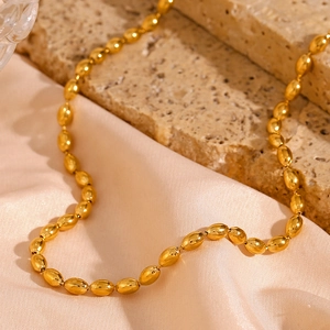 Detailed macro view of 18K gold plated oval bead chain necklace on silk background