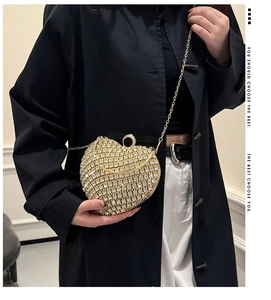 Chic gold heart-shaped rhinestone clutch bag styled with a modern chain strap for evening wear