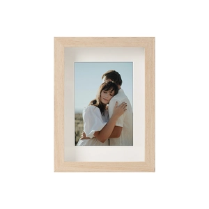 Detail of solid wood hollow photo frame with white mat and warm couple portrait