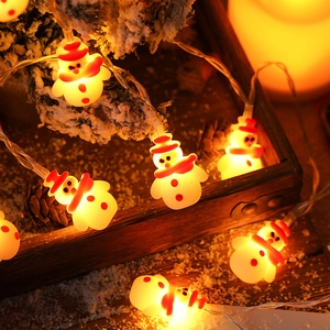 LED snowman string lights with warm glow for festive Christmas home decor on wooden background