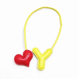 Dettaglio di un ciondolo per borsa in pelle fatto a mano con cuore rosso e lettera Y