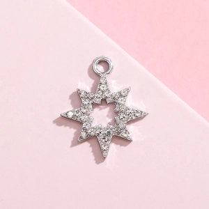Macro shot of a silver snowflake pendant with sparkling white rhinestones on pink