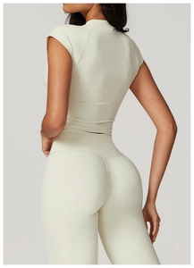 Vista dettagliata del set yoga bianco crema con top a maniche corte e leggings a vita alta