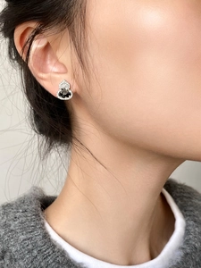 Close-up of elegant gourd-shaped earring with black center stone on model's ear