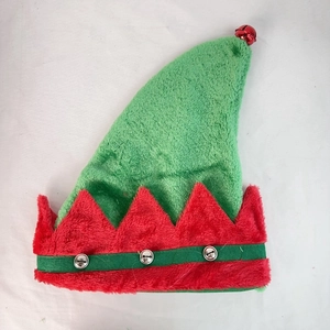 Detail of red and green plush Christmas elf hat featuring small silver bells and soft texture