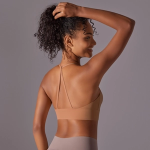 Detail of cross-back thin straps and wide support band on a beige sports bra