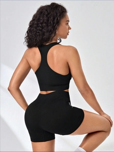 Detail view of seamless racerback sports bra and high-waist shorts set with side lettering