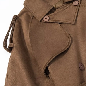 Macro shot of brown faux suede trench coat details with lapels, epaulettes, and buttons