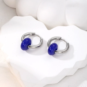 Macro shot of silver stainless steel earrings with dark blue natural stone ring pendants
