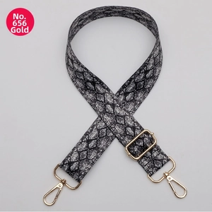 Detail of adjustable black and white python pattern bag strap with gold metal hooks