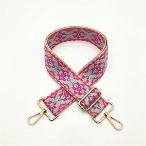 Close-up of ethnic geometric woven strap with gold metal buckles and adjustable slider