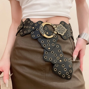 Macro detail of bohemian leather waist chain with baroque gold buckle and metal eyelets