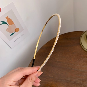 Detailed view of handmade gold metal headband with elegant white pearls and soft end tips