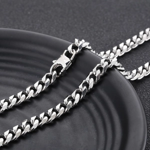 Detailed close-up of a silver titanium steel Cuban link chain with a sturdy lobster clasp