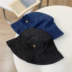 Detail view of denim bucket hats with decorative side pockets and metallic buckle accents